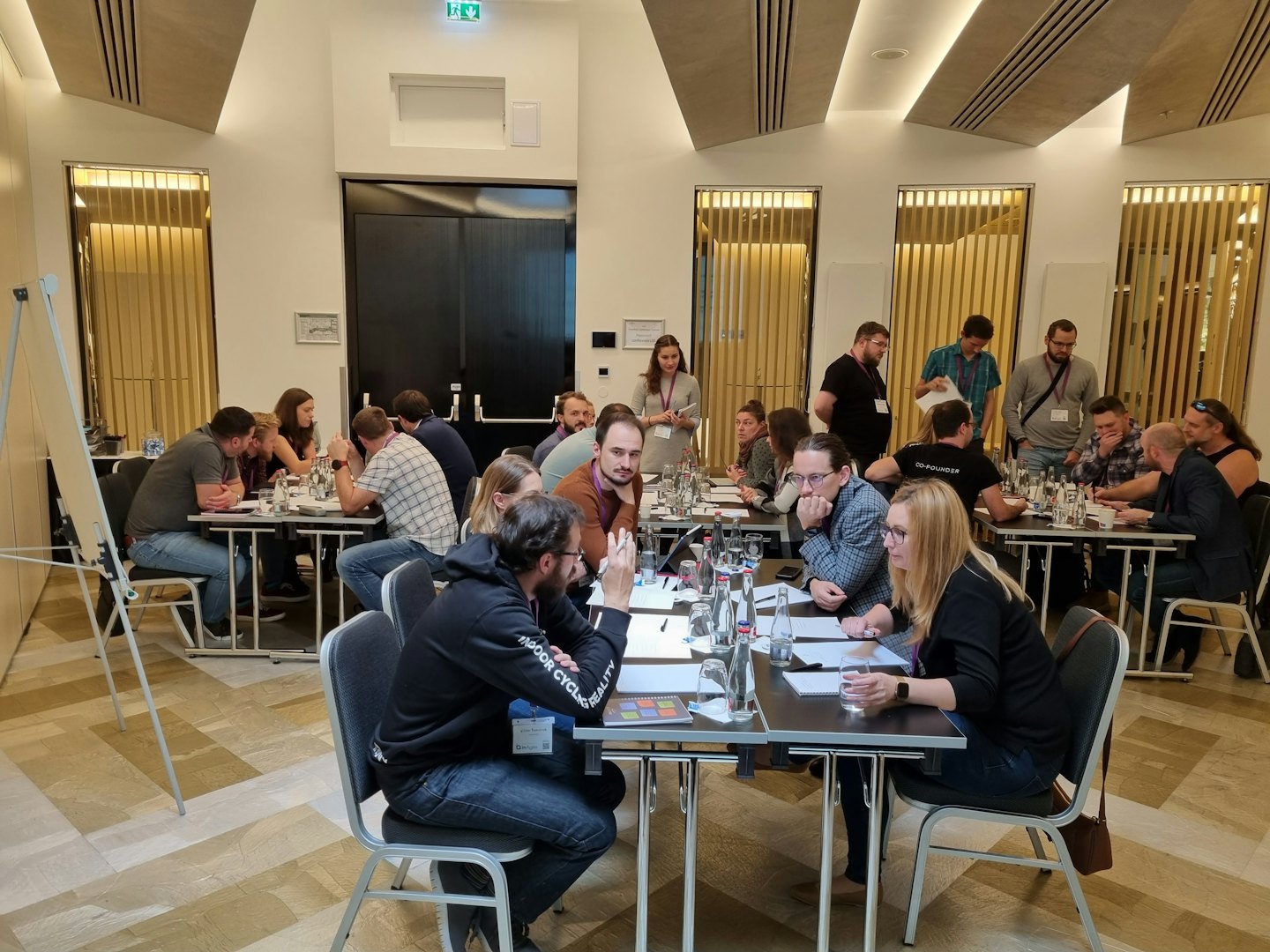 Adults attending a business workshop around tables.