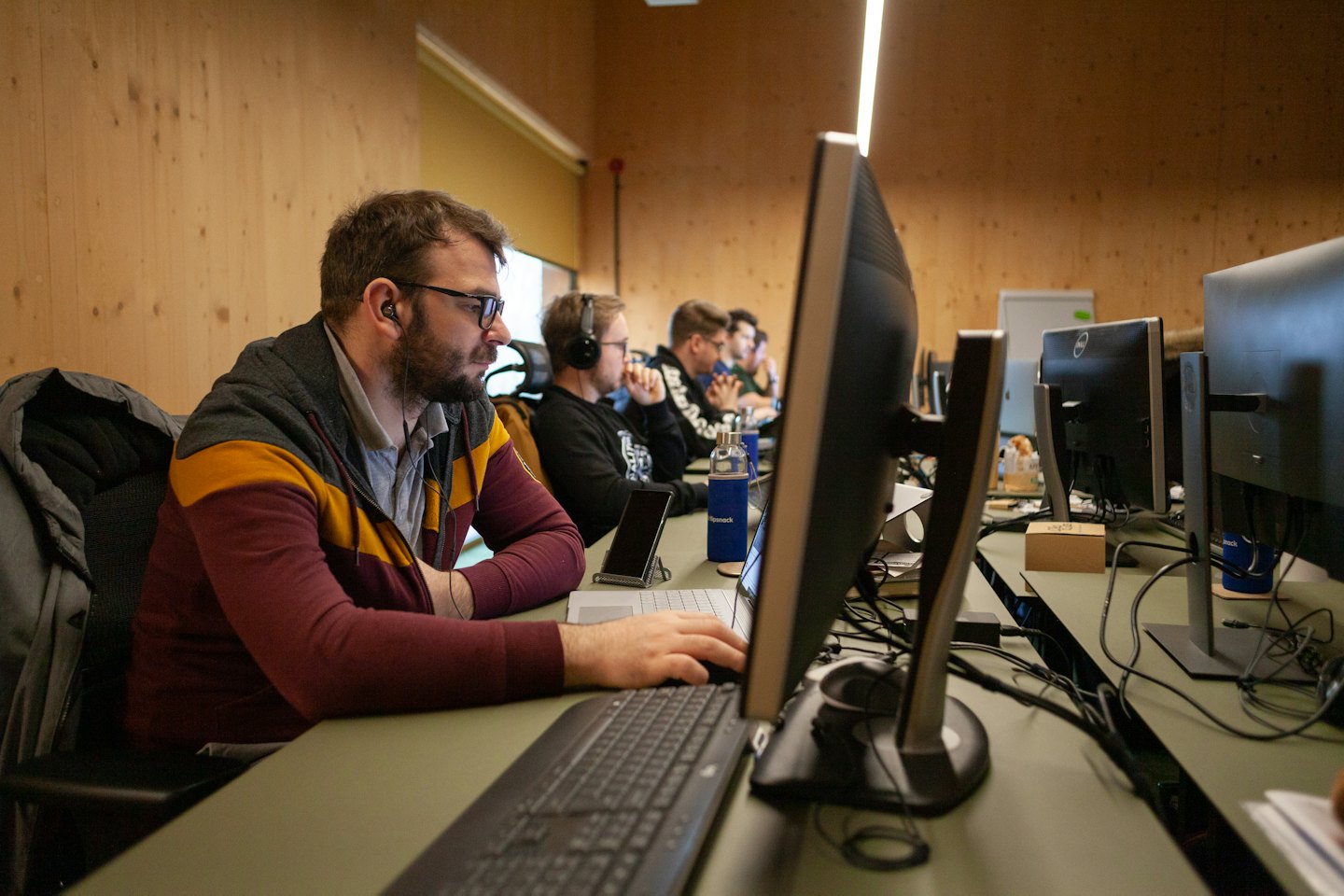 Men in a modern office focused on computer screens.