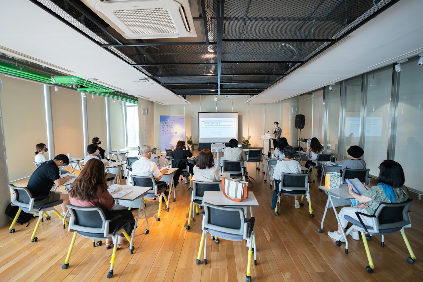 Attendees listen to a presenter in a modern seminar room.